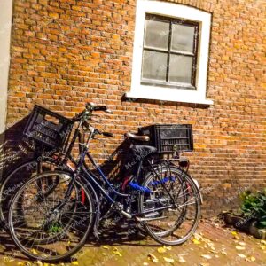 Bicycle parked at brown house in Amsterdam