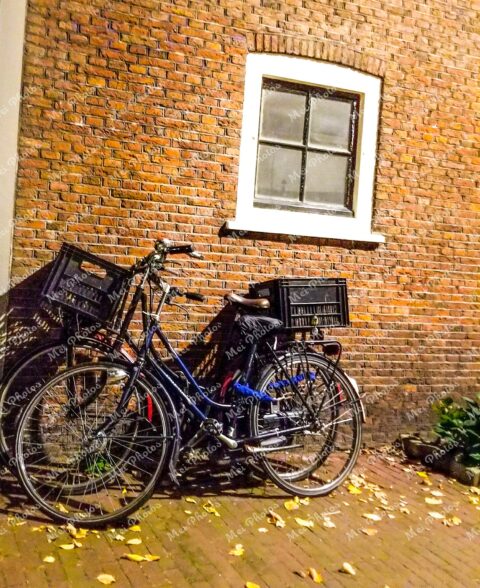 Bicycle parked at brown house in Amsterdam