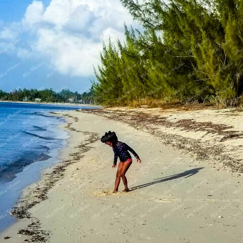 Girl Playing in Sand At Sandy Point Beach With Blue Sky In Abaco The Bahamas 19