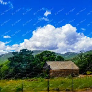 Blue sky and wooden house on dirt road on Safari in South Africa